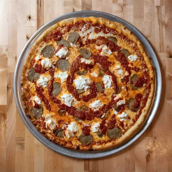 A NY Pizza Place pizza with sausage, ricotta, and tomato sauce on a metal pan.